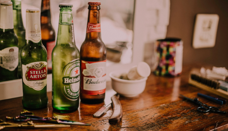A collection of popular beer bottles from around the world displayed on a wooden table, featuring prominent brands from Germany, Mexico, and India. The German beers are represented by classic steins, the Mexican beers are showcased with colorful labels, and the Indian beers are highlighted with traditional logos. The background includes subtle elements like flags and cultural icons from each country, emphasizing the international variety. This image captures the essence of the blog topic, illustrating the diverse and popular beer brands enjoyed globally, perfect for readers interested in exploring different beer cultures.