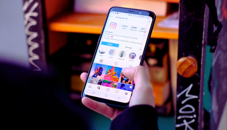 An image showing a smartphone screen displaying Instagram Reels, with vibrant video thumbnails, likes, and comments. Indian currency symbols are floating around the screen, symbolizing earning potential. The background features elements of Indian culture, such as a traditional pattern, emphasizing the blog's focus on how to Make Money From Instagram Reels In India.